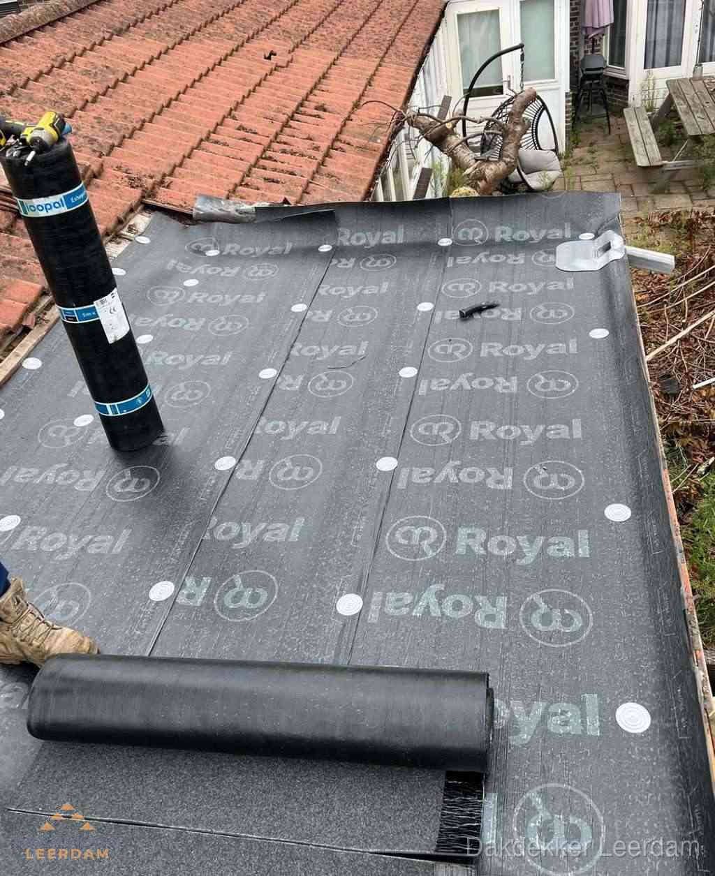 Plat dak met nieuwe bitumen dakbedekking en brandgereedschap in Leerdam