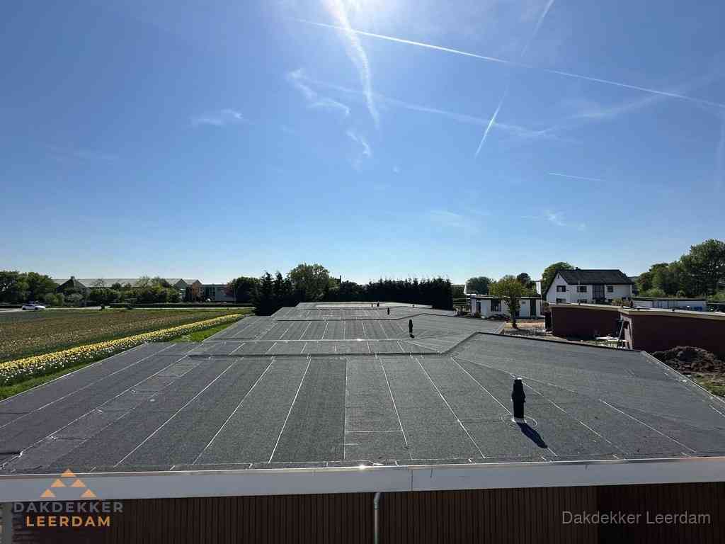 Groot plat dak met bitumen dakbedekking op bedrijfspand in Leerdam