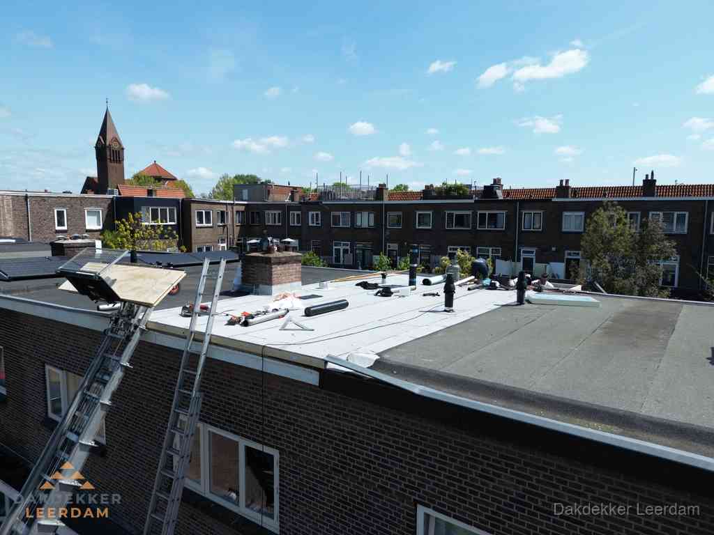 Dakdekkers aan het werk op plat dak in Leerdam