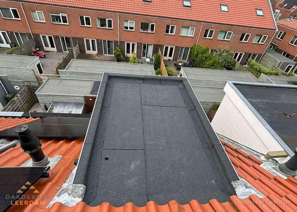 Plat dak met bitumen bedekking naast dakkapel in Leerdam