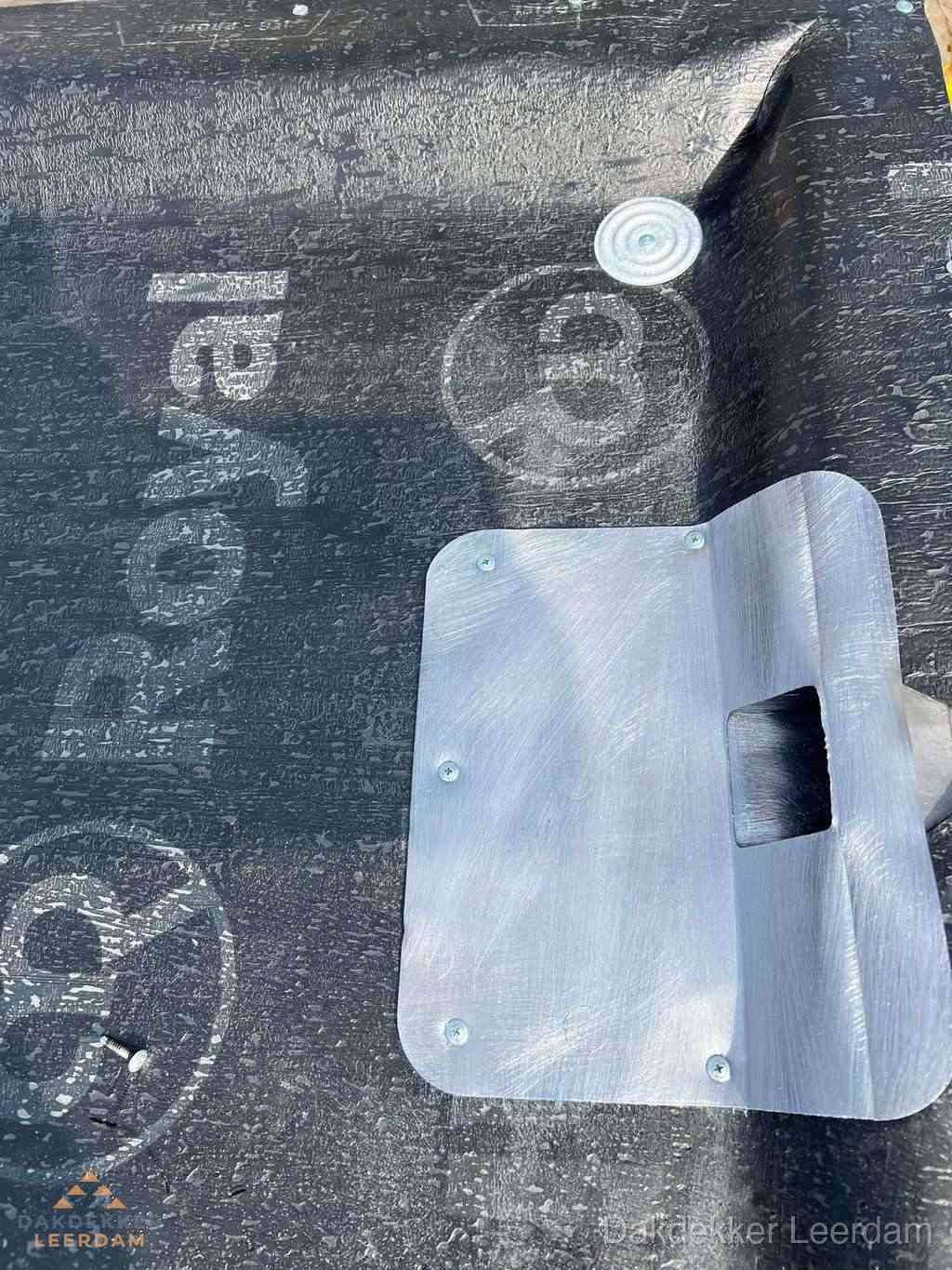 Dakdoorvoer met metalen afvoerplaat op bitumen dak in Leerdam