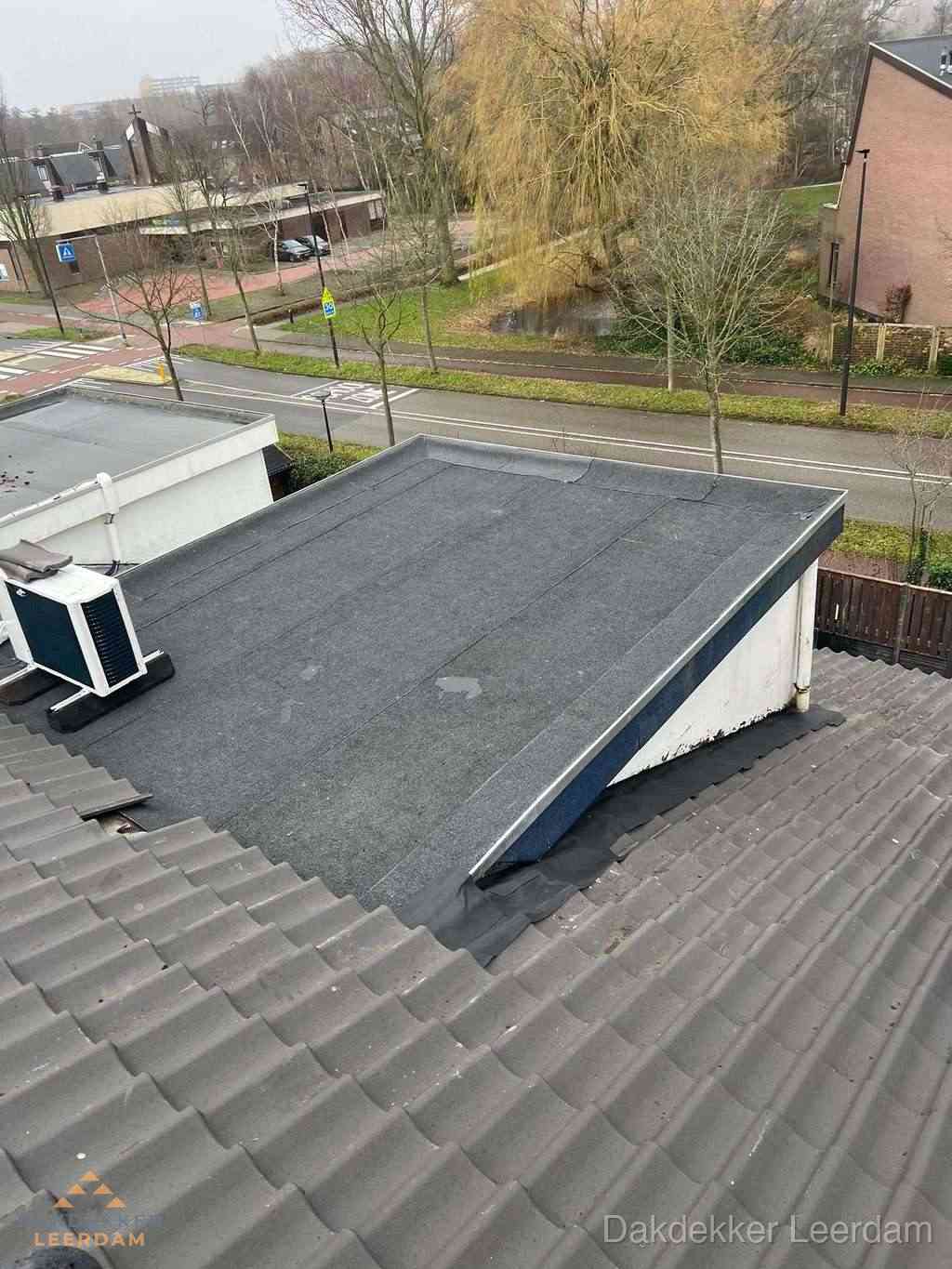 Plat dak met bitumen dakbedekking naast schuin pannendak in Leerdam