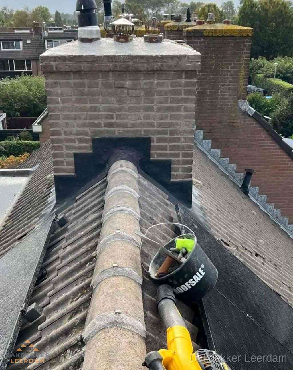 Dakdekker repareert bitumen dakleer bij dakdoorvoer in Leerdam
